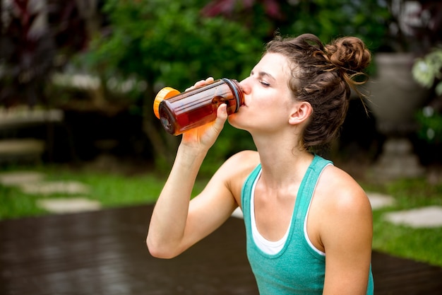 Giovane donna rinfrescante con acqua potabile