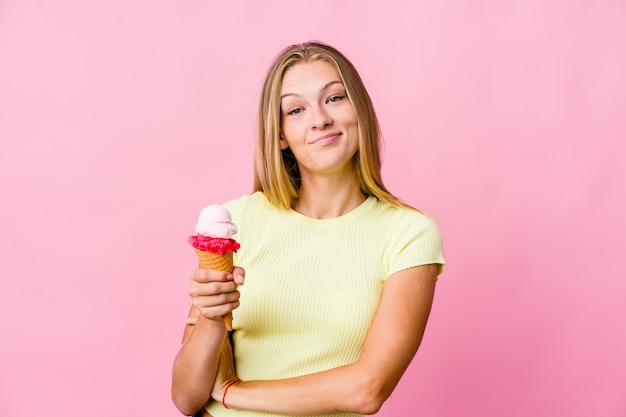 Giovane donna russa che mangia un gelato isolato che si sente sicura, incrociando le braccia con determinazione.