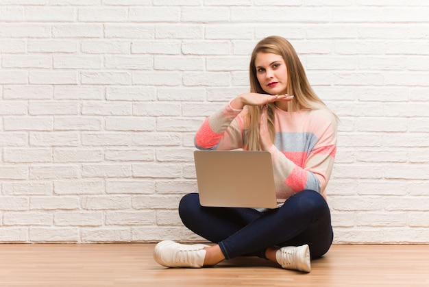 Giovane donna russa dello studente che si siede facendo un gesto di timeout