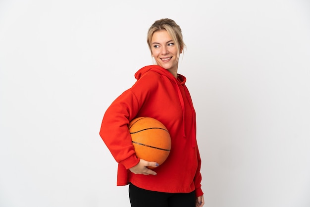 Giovane donna russa isolata su bianco giocando a basket