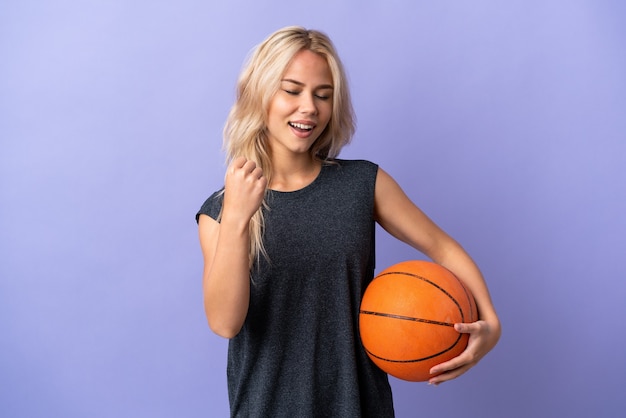 Giovane donna russa isolata su viola giocando a basket