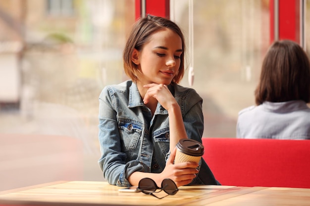 Giovane donna seduta al caffè