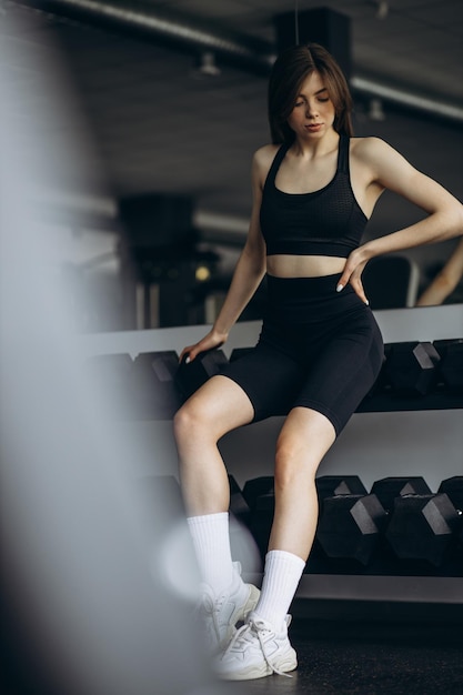 Giovane donna seduta in palestra