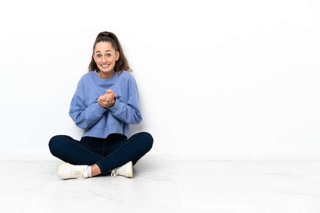 Giovane donna seduta per terra che ride