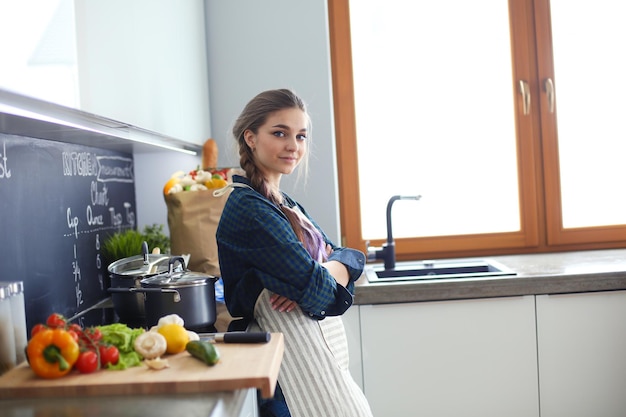 Giovane donna seduta sul tavolo in cucina