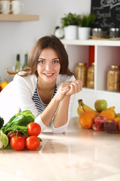 Giovane donna seduta vicino alla scrivania in cucina