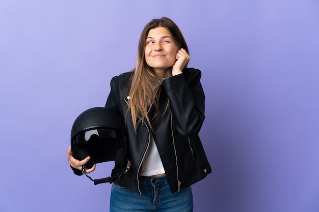 Giovane donna slovacca che tiene un casco del motociclo isolato sulle orecchie frustrate e coprenti viola