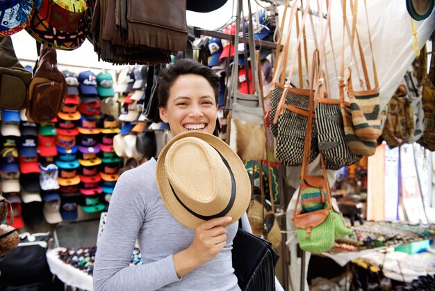 Giovane donna sorridente al mercato di acquisto