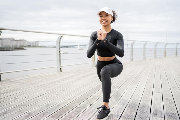 Giovane donna sorridente allenamento fitness in città Orologio fitness e app per lo sport