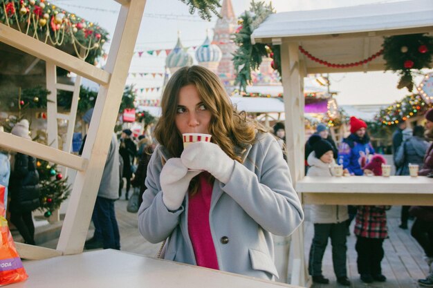 Giovane donna sorridente che beve caffè in tazza