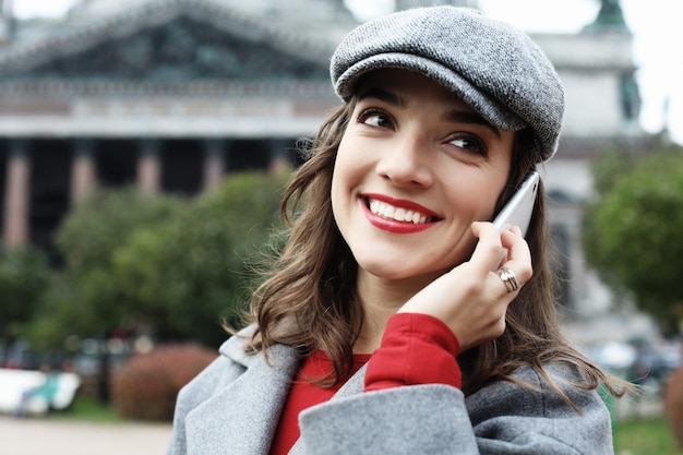 Giovane donna sorridente che chiama e parla su smartphone