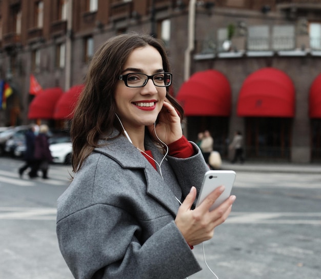 Giovane donna sorridente che chiama e parla su smartphone