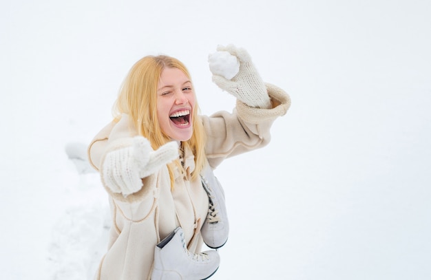 Giovane donna sorridente che gioca con la neve