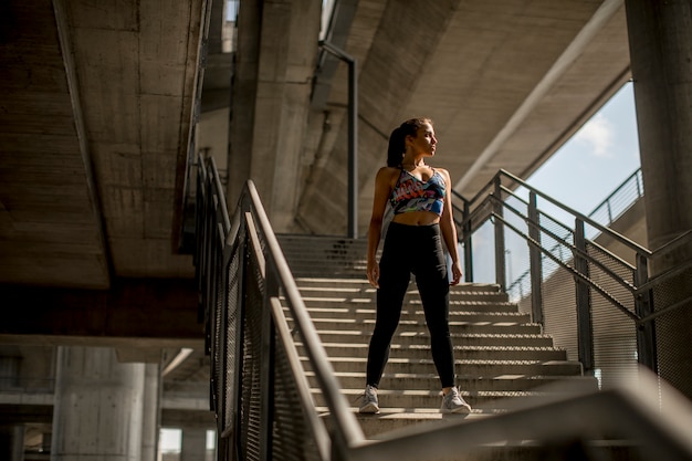 Giovane donna sorridente che riposa dopo un allenamento fitness attivo