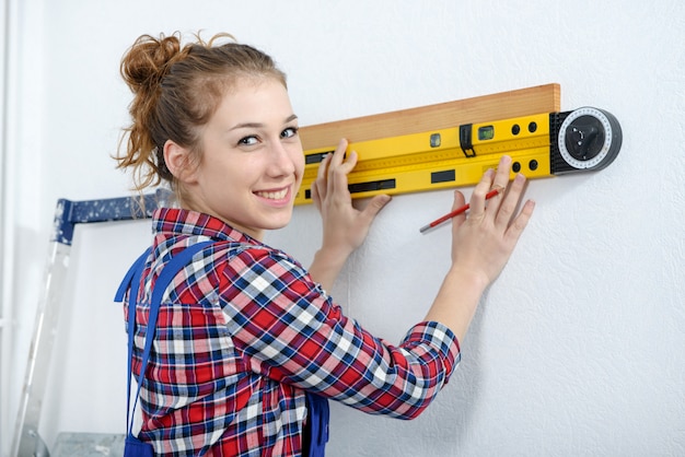 Giovane donna sorridente che usando il livello di spirito