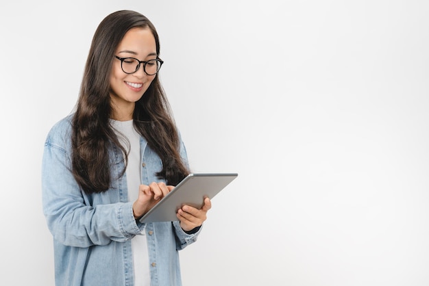 Giovane donna sorridente che utilizza computer tablet isolato su sfondo bianco