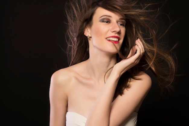 Giovane donna sorridente con il primo piano di movimento dei capelli