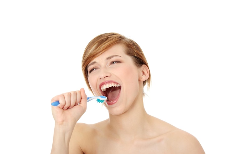 Foto giovane donna sorridente con lo spazzolino da denti sullo sfondo bianco
