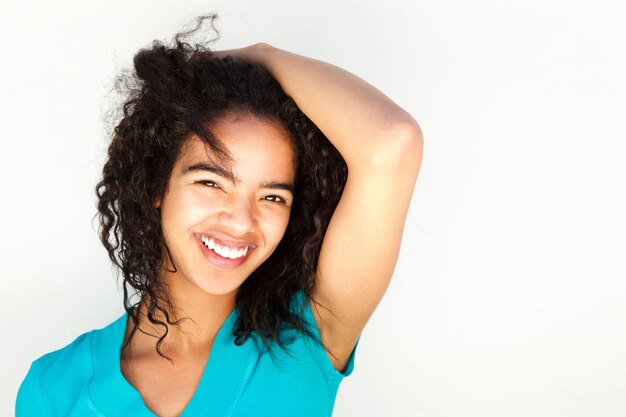 Giovane donna sorridente con mano in capelli