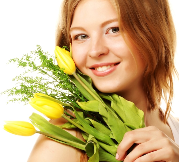 Giovane donna sorridente con tulipani gialli