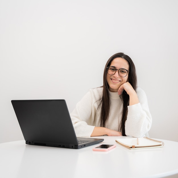 Giovane donna sorridente e lavorando con il computer portatile