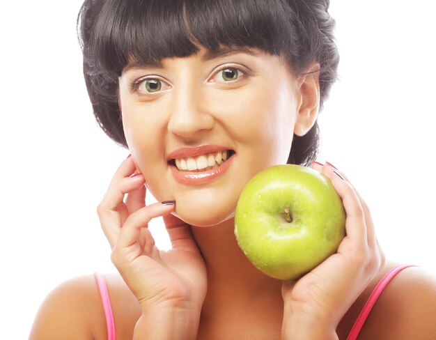 Giovane donna sorridente felice con la mela verde
