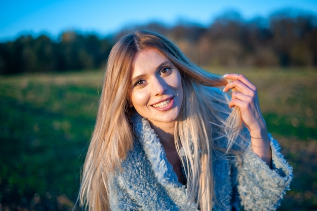 Giovane donna sorridente felice di modo nel campo di autunno