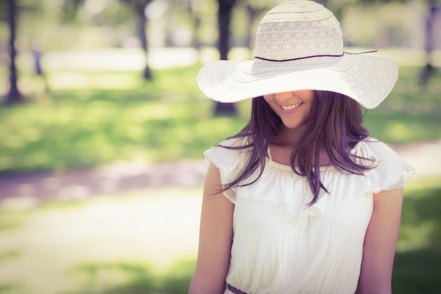 Giovane donna sorridente in cappello del sole