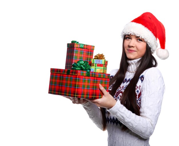 Giovane donna sorridente in cappello rosso di natale a sfondo bianco con doni