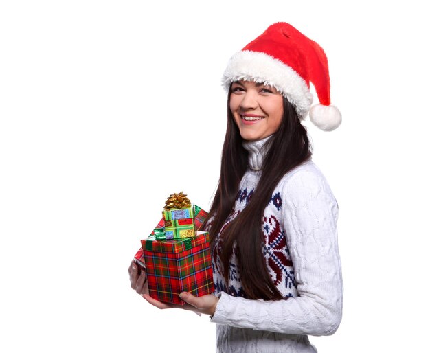 Giovane donna sorridente in cappello rosso di natale a sfondo bianco con doni