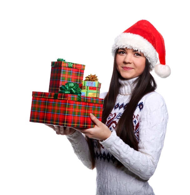 Giovane donna sorridente in cappello rosso di natale a sfondo bianco con doni