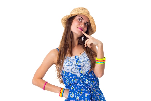 Giovane donna sorridente in maglietta blu e pantaloncini con braccialetti colorati e cappello che mostrano felicità