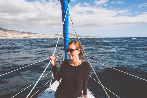 Giovane donna sorridente seduta in una barca in mare