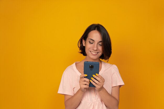 Giovane donna sorridente utilizzando il telefono