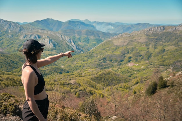 Giovane donna sottolineando un paesaggio montuoso nelle Asturie Spagna Pena Mea trail fuori fuoco