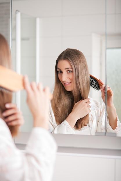 Giovane donna spazzolarsi i capelli