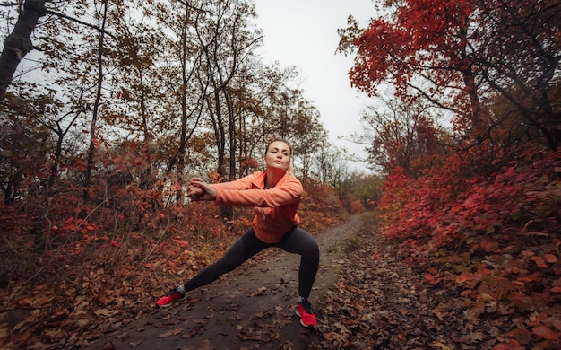 Giovane donna sportiva attraente in abiti sportivi facendo esercizio di stretching