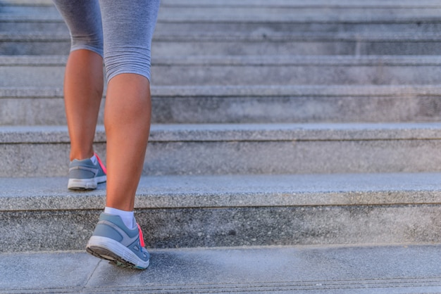 giovane donna sportiva che corre al piano di sopra sulle scale della città