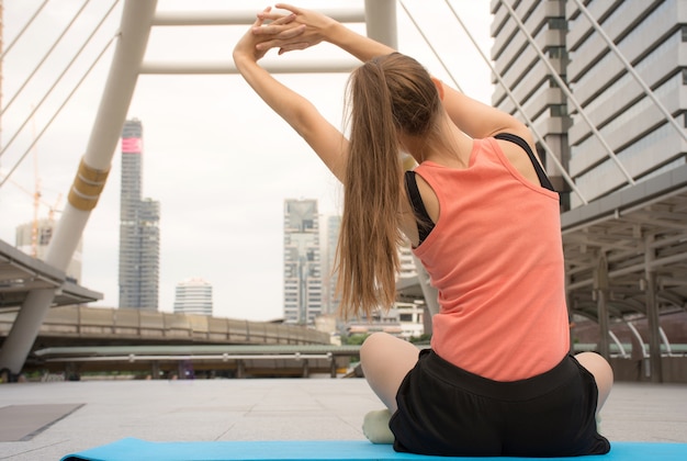 Giovane donna sportiva che fa yoga all&#39;aperto / stile di vita attivo