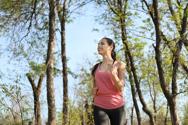 Giovane donna sportiva che funziona nel parco