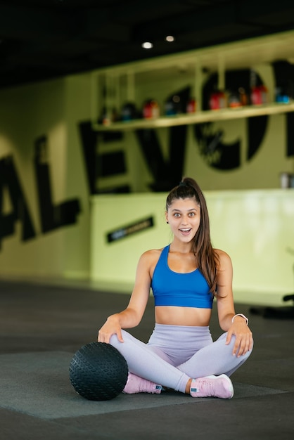 Giovane donna sportiva che guarda alla telecamera in palestra