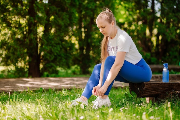 Giovane donna sportiva che riposa dopo gli allenamenti al parco