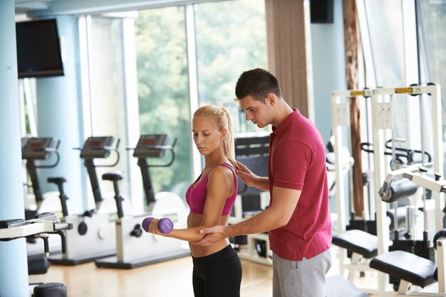 giovane donna sportiva con esercizi di sollevamento pesi in palestra fitness