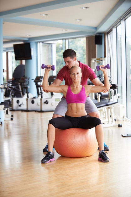 giovane donna sportiva con esercizi di sollevamento pesi in palestra fitness