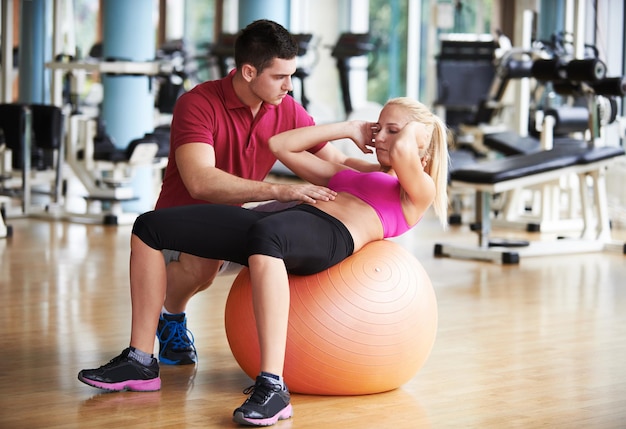 giovane donna sportiva con esercizio di allenatore in palestra fitness