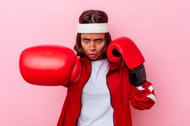 Giovane donna sportiva di razza mista con guantoni da boxe isolati sulla parete rosa