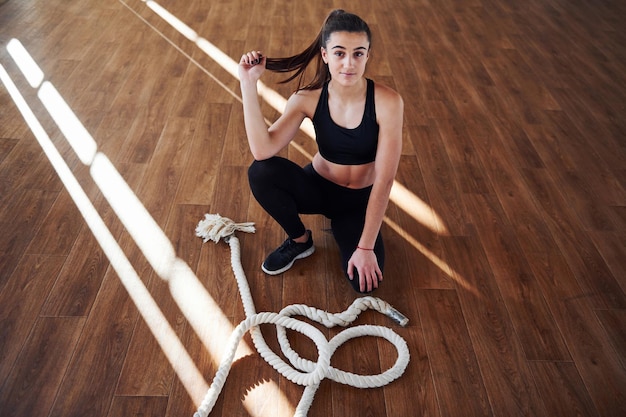 Giovane donna sportiva in abbigliamento sportivo stanca e fa una pausa in palestra.