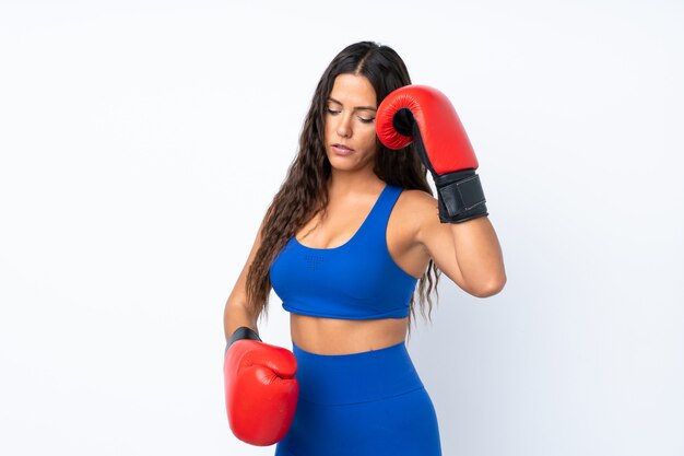 Giovane donna sportiva sopra isolata con guantoni da boxe