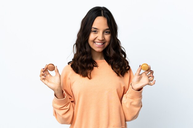 Giovane donna su sfondo bianco isolato azienda colorati macarons francesi