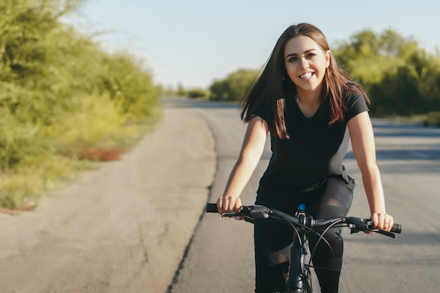 Giovane donna su una bicicletta su strada